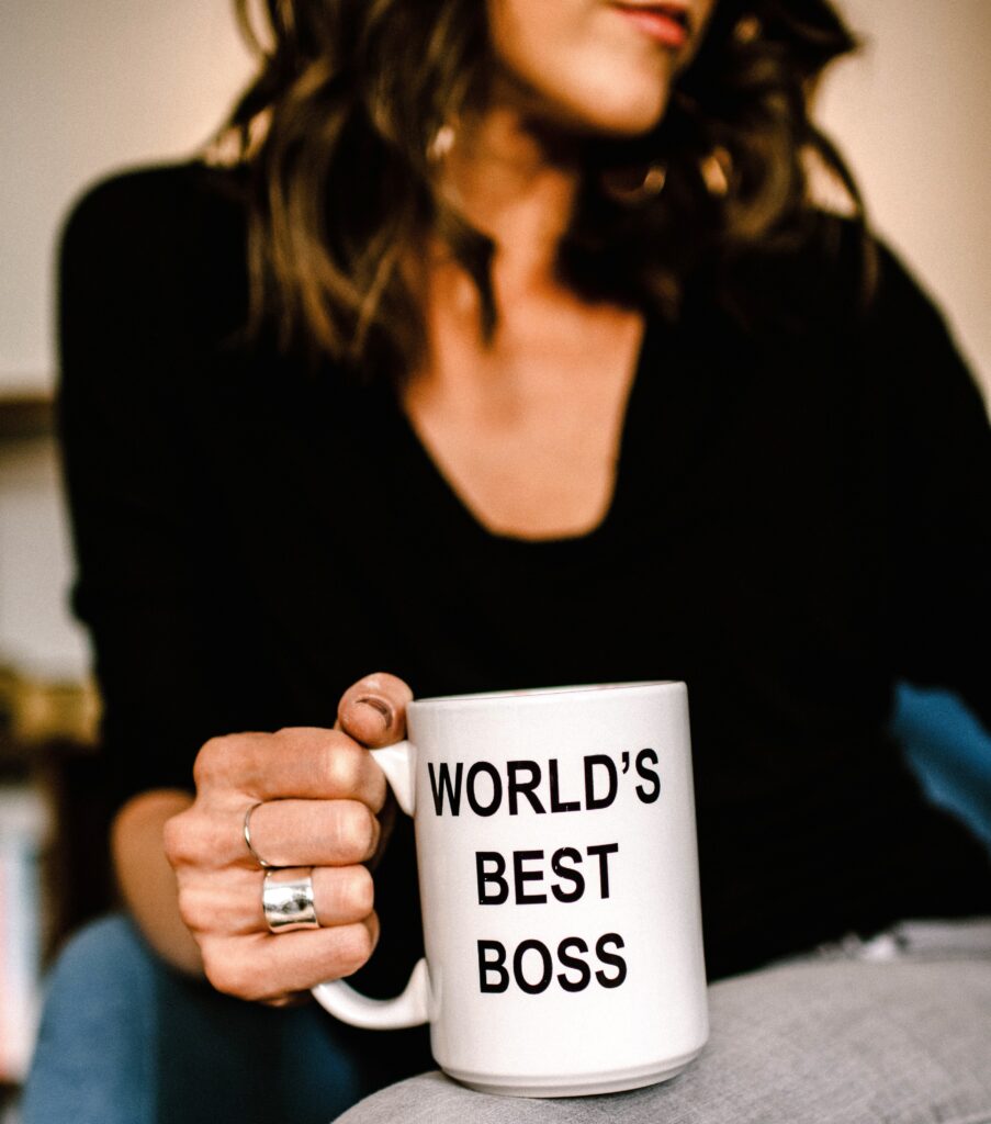 Woman holds white mug that says World's Best Boss