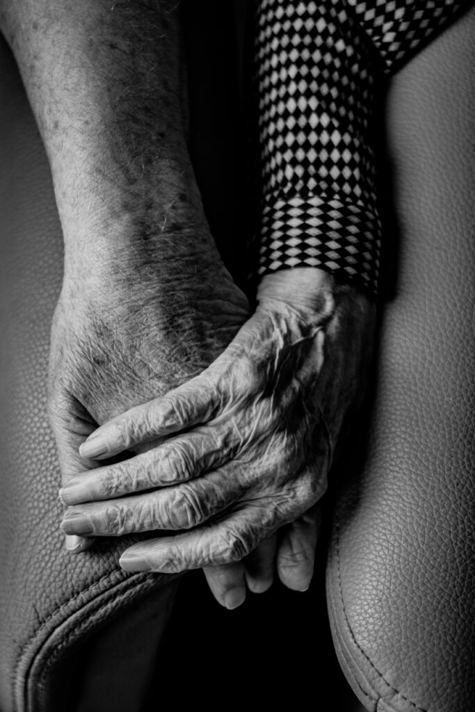 Black and white image of two aging adults holding hands